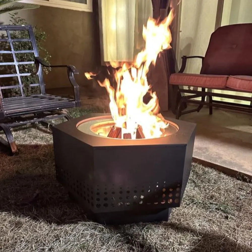 Fire pit with flames in a backyard setting with chairs and a table.
