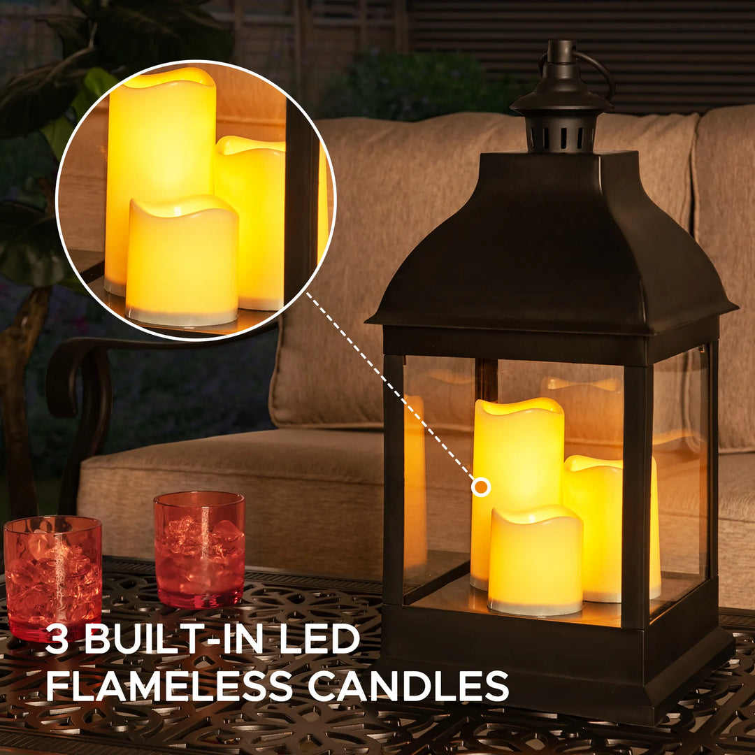 Black lantern with built-in LED flameless candles on a table outdoors.